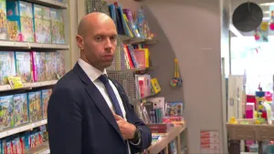 Foto van een man, netjes gekleed, in een winkel.