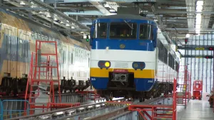 Foto van grote reparatiehal met treinen erin voor reparatie.