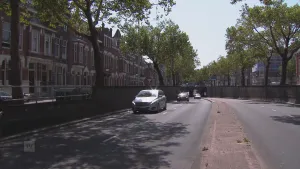 Foto van een grote weg door een stad waarop auto's rijden.