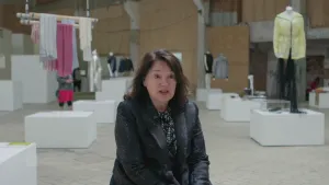 Foto van presentator in een grote modezaak met ook modepoppen erin.