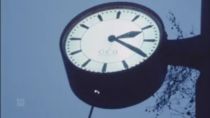 Foto van een ronde openbare klok met wijzers buiten.