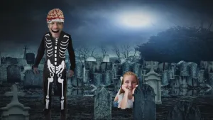 Foto van een kerkhof 's nachts met ervoor man als skelet verkleed en een vrolijk kijkend meisje.