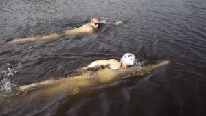 Foto van twee zwemmers in het water die zwemmen/crawlen.