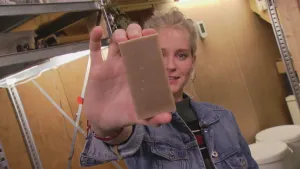 Foto van presentator die een stuk zeep vasthoudt en laat zien.