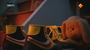 Foto van Dropje, een stoffen pop, die staat bij aantal schoenen, van rolschaatsen.