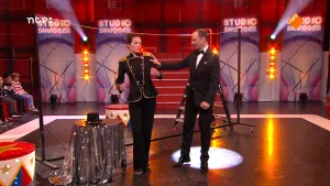 Foto van de studio van Snugger waarbij de presentator bij een verklede vrouw staat op het podium.