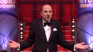 Foto van Studio Snugger met de presentator die staat in de studio en iets vertelt.