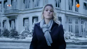 Foto van NOS-Journaal van presentator met op de achtergrond grote oude zwart/wit foto van een gebouw.