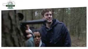 Foto van man en vrouw in een bos, je ziet nog deel van iemand anders die een geweer vasthoudt.