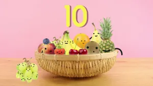 Tekening van een fruitmand met stukken fruit met gezichtjes erin, ernaast trosje met tien groene druiven, erboven het getal tien.