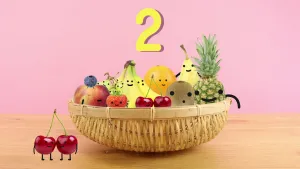 Tekening van een fruitmand met stukken fruit met gezichtjes erin, links ervan twee kersen, erboven het cijfer twee.