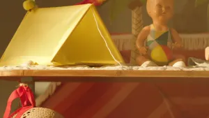 Foto van een plank met speelgoed erop, onder andere een kleine namaaktent.