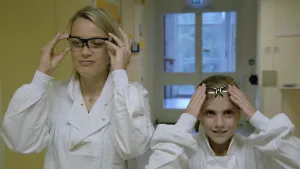 Foto van vrouw en meisje met witte werkkleding aan en beiden een beschermbril voor de ogen op.