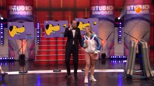 Foto van Studio Snugger met man en meisje op het toneel/podium, verder zie je drie tekeningetjes van een gele hondenkop.