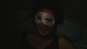 Foto, heel donker, van een portret van iemand die een ogenmaskertje op heeft.