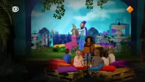 Foto van iemand die voorleest aan kinderen met op de achtergrond een decor uit een bijbelverhaal.