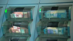 Foto van een machine, close-up, met Eurobiljetten erin, tientjes en twintigjes.