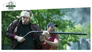 Foto van twee presentatoren waarvan één een blaasapparaat vasthoudt.