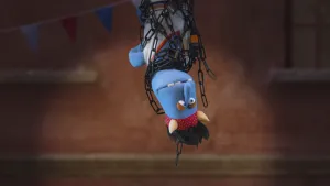 Foto van Stuntman Stefan (pop) die op de kop hangt geboeid in kettingen.