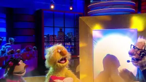 Foto van scène uit de Boterhamshow met de studio waarbij Opperdepop met twee figuren aan tafel zit, één van die twee alleen het silhoutte, brandweerman, erbij nog Berny in beeld.