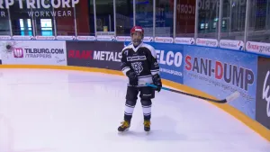 Foto van een ijshockeyer op de ijsbaan.