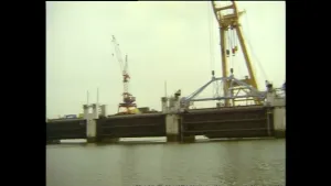 Foto van de bouw van deel van de Oosterscheldekering, met o.a. grote hijskranen in beeld.