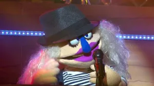 Foto van scène uit de Boterhamshow met portret van Ilse DeBange (pop) in de studio die zingt in microfoon.