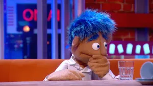 Foto van scène uit de Boterhamshow van Rik (portret) aan de desk in de studio.