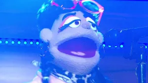 Foto van scène uit de Boterhamshow met portret van pop die zingt.