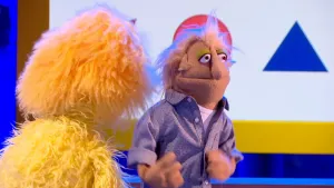 Foto van scène uit de Boterhamshow met Hendrik Hoogmoed (pop) aan de desk met Opperdepop.