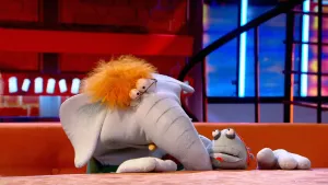 Foto van scène uit de Boterhamshow met Olivier Olifant en Lex Goudvis (twee stoffen poppen), aan tafel.