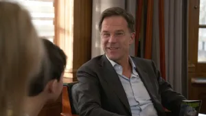 Foto van Mark Rutten, Minister-President, die ondervraagd wordt door paar kinderen.