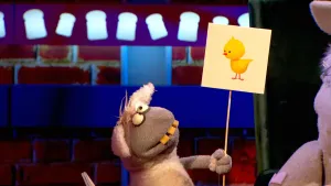 Foto van Boterhamshow waarbij Nico de Neushoorn gedicht voordraagt en houdt tekening vast van een kuiken.