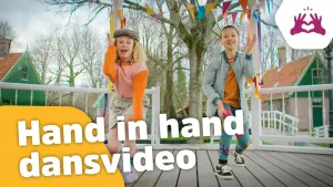 Foto van twee dansende kinderen op een bruggetje in stadje met ervoor de tekst: Hand in hand dansvideo.