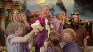 Foto van toneelsetting met een keizer die wordt geïnterviewd door andere personen.