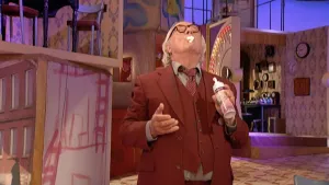 Een foto van meneer Aart, die een bus met slagroom vastheeft. Hij heeft zijn nek naar achteren en zijn hoofd omhoog in de lucht gestoken. Op zijn lippen zit een stuk witte slagroom. Hij heeft zijn ogen dicht terwijl hij de slagroom opeet.