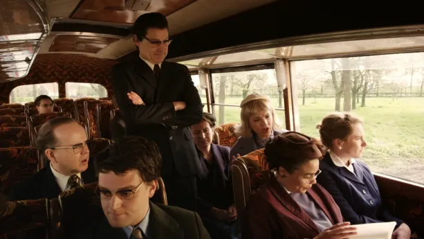 Een foto van mensen in een bus. Op één stoel rechts zit een vrouw verkleed als Rosa Parks een boek te lezen. Een man die links zit en een vrouw achter Rosa kijken boos naar haar. Een man die in het midden staat kijkt naar Rosa met zijn armen over elkaar.