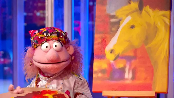 Een foto van pop Bernadette Aquarel die met grote ogen naar de camera kijkt en een schilderij van een goudgeel paardenhoofd. Ze heeft een houten palet of bord met verf erop vast en verfvlekken op haar blouse. Op haar hoofd zit een hoofddoek en een bril.