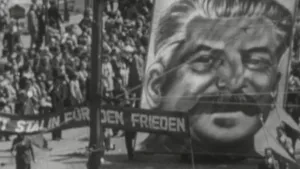 Een foto van een groep mensen met ervoor een groot spanddoek waarop het getekende gezicht staat van Josef Stalin, de leider van de Sovjet-Unie. Een spandoek met daarop "Stalin für den frieden", "Stalin voor de vrede" wordt gedragen door twee mensen.