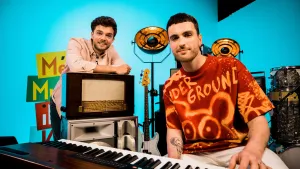 Een foto van Buddy die zijn armen heeft liggen op een oude radio van hout. Ervoor zit Duncan Laurence achter een elektrische piano. Duncan draagt een rood t-shirt met oranje lijnen in de vorm van een berenkop erop en de tekst "Under Ground" erboven. 