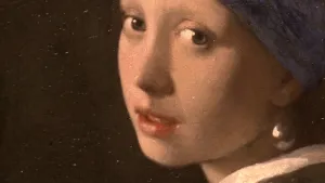 Een foto met daarop een gedeelte van het schilderij "Het meisje met de parel"  van Johannes Vermeer. Op het schilderij kijkt het meisje naar achteren. Ze heeft een grote, geelachtige parel in haar oor. Het is geen portret, maar een fantasieschilderij. 