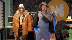 Een foto met Céline gekleed in lichtbruine jas, legerbroek met groene, bruine en zwarte vlekken, witte blouse met kleurige vlekken en witte hoed. Tim is gekleed in lichtblauwe tuinbroek, kleurig shirt, lichtbruin hoedje en zwart heuptasje om de schouder.