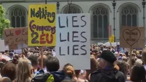 Een foto van een grote groep mensen in Groot-Brittannië die  demonstreren om in de Europese Unie te blijven. Op borden staat "We Love EU", "We houden van de EU" en "Together is Better", "Samen is beter". Achteraan staat een wit gebouw met grote ramen.