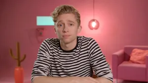 Een foto van presentator Jard in de roze Dikke Data Show studio. Hij kijkt in de camera. Op de achtergrond zie je allemaal spullen die een roze kleur hebben.