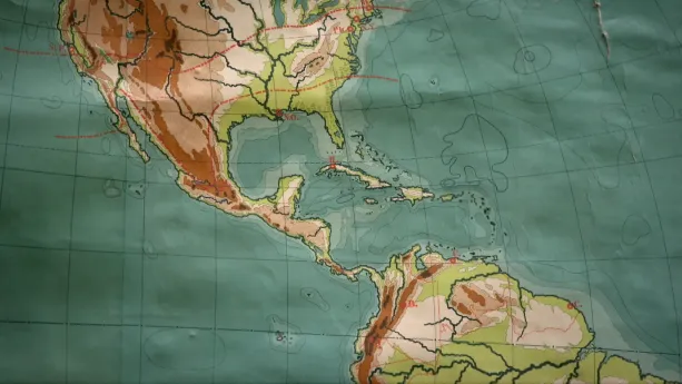 Een foto van een deel van een oude wereldkaart van rond 1899. Op de kaart is een deel van Noord-Amerika en de bovenkant van Zuid-Amerika te zien. Het smalle stuk land dat beide delen verbindt, de landengte van Panama genoemd, is op de kaart te zien.
