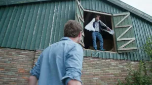 Een foto van de presentatoren Pieter en Willem. Pieter staat buiten bij een hoge schuur. Willem staat in een opening van die schuur, en dan wel vier meter van de grond. Hij heeft vleugels aan zijn armen vastgemaakt.
