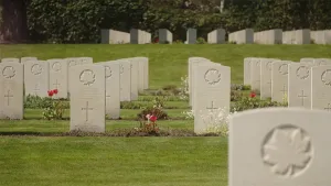 Een foto van een Canadese begraafplaats. Er zijn veel grafstenen te zien en er zijn bloemen tussen de stenen in.