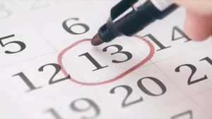 Een foto van een kalender waarin vakjes met getallen staan. Er is niet te zien welke maand het is, of welke dag het is. Met een zwarte stift met rode punt is een rode cirkel gezet om het vakje met nummer dertien erop. Zou het vrijdag de dertiende zijn?