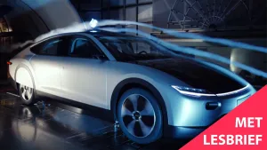 Een foto van een moderne auto die in een windtunnel staat waar wordt gekeken hoe de wind langs de auto heen stroomt. Rechtsonder staat de tekst 'Met lesbrief'.