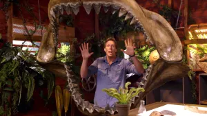 Een foto van presentator Freek die in de studio achter de kaken staat van de grootste haaisoort die ooit geleefd heeft.